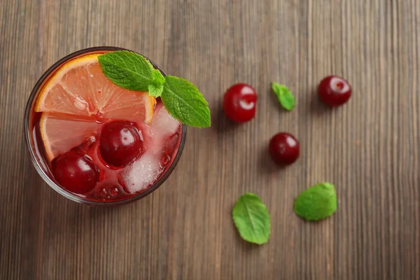 Glass of cherry juice on wooden table, top view — Stock Photo, Image