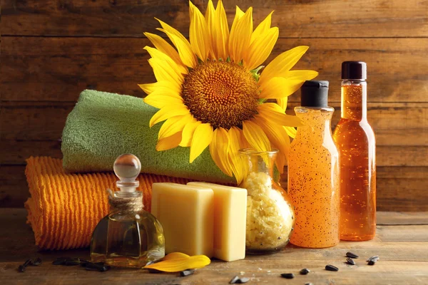 Massage oil and spa treatments, sunflower on wooden background — Stock Photo, Image