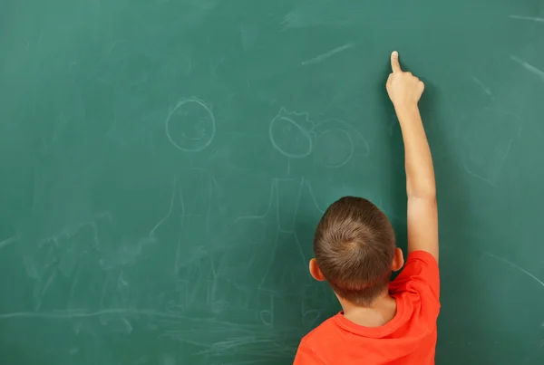 Küçük çocuk bir şey kara tahta üzerinde işaret — Stok fotoğraf