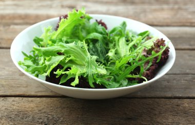 ahşap zemin üzerine karışık yeşil salata kâsesi