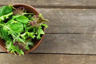 Kase üzerinde ahşap masa, üstten görünüm karışık yeşil salata
