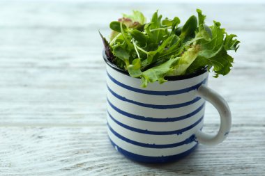 Taze karışık yeşil salata Kupası ahşap masa üzerinde kapat