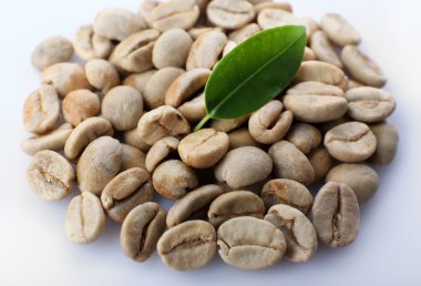 Yeşil kahve çekirdekleri ile yaprak yığını kapat