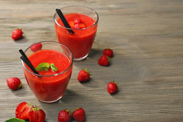 Briller av jordbærsmoothie med bær på bordet av tre – stockfoto