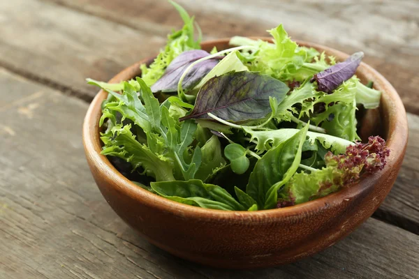 Salada verde mista fresca em tigela na mesa de madeira close-up — Fotografia de Stock