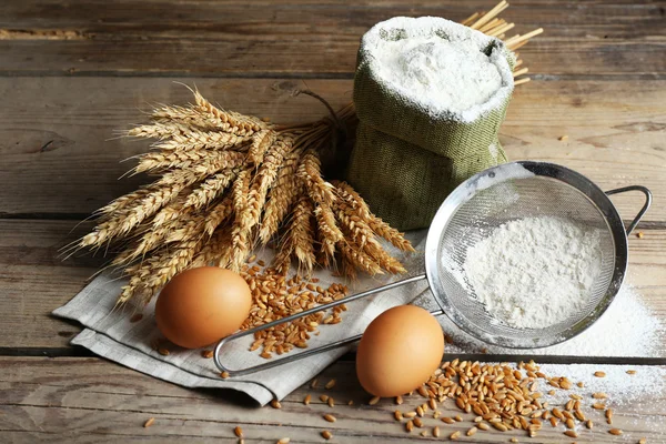 Flour and wheat on wooden table — Stock Photo, Image