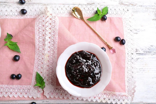 Tasty currant jam with berries on table close up — Stock Photo, Image