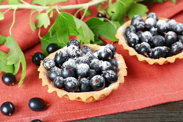 Délicieuses tartes croustillantes avec cassis sur serviette rouge, gros plan — Photo