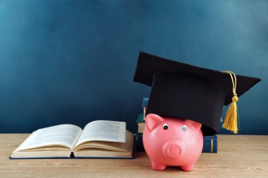 Kitap ve grad şapka ile Piggy banka