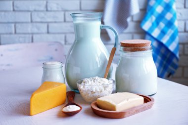 Tuğla duvar arka plan üzerinde ahşap masa üzerinde süt ürünleri