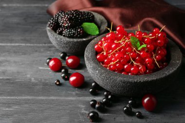 Orman meyveleri kase ahşap arka plan üzerinde