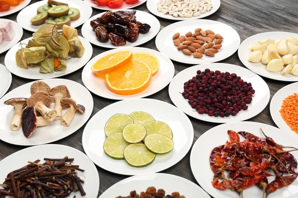 Different products on saucers on wooden table, closeup — Stock Photo, Image