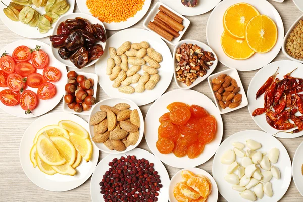 Different products on saucers on wooden table, top view — Stock Photo, Image