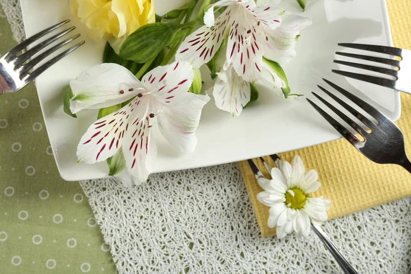 Vajilla con flores en la mesa — Foto de Stock