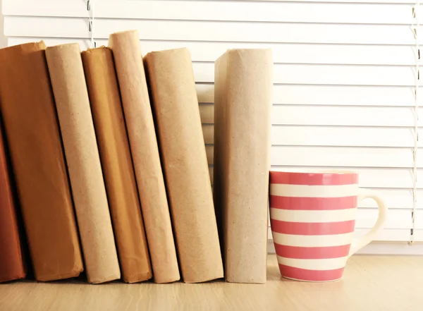 Books and cup on windowsill — Stock Photo, Image