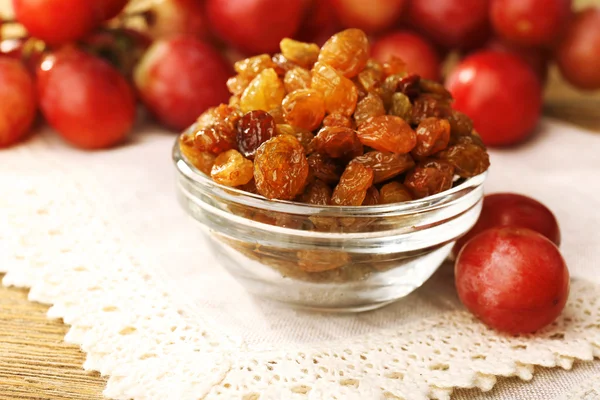 Raisins in bowl with grapes on table close up — Stock Photo, Image