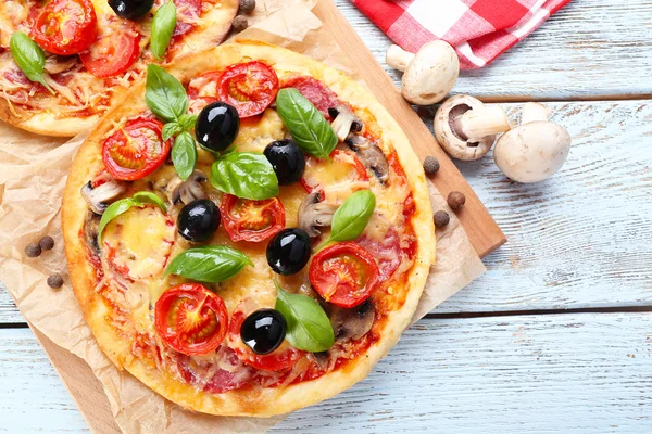 Sabrosa pizza con verduras y albahaca en la mesa de cerca —  Fotos de Stock