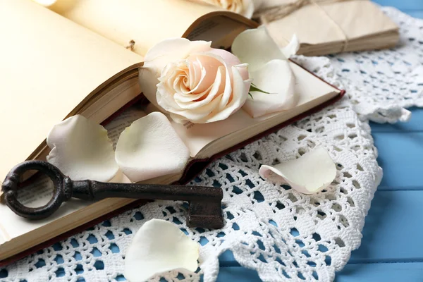Свежие розы со старой книгой и письмами — стоковое фото