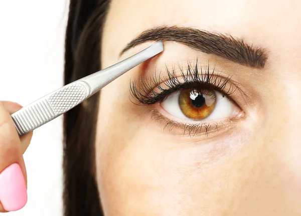Young woman plucking eyebrows — Stock Photo, Image