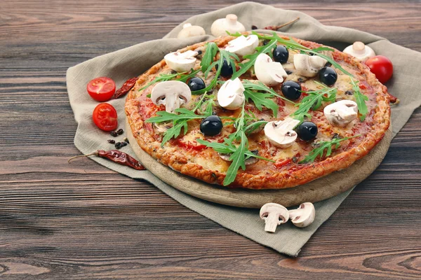 Вкусная пицца с овощами и рукколой на столе — стоковое фото