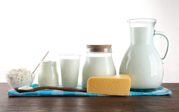 Молочные продукты на деревянном столе на белом фоне — стоковое фото