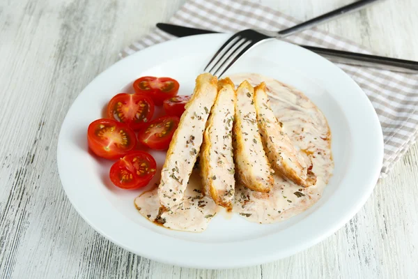 Slices of chicken fillet with spices and cherry tomato on table close up — Stock Photo, Image