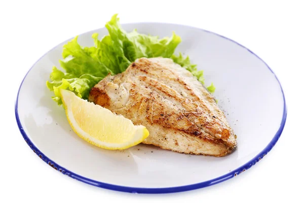 Dish of fish fillet with lettuce and lemon on plate close up — Stock Photo, Image