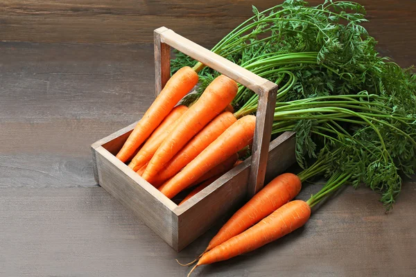 Zanahorias orgánicas frescas en caja sobre fondo de madera — Foto de Stock