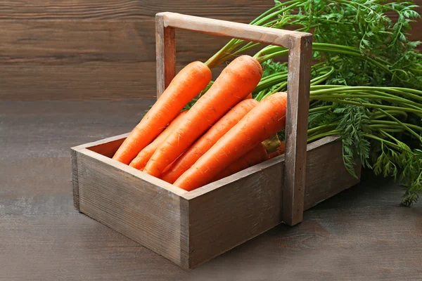 Zanahorias orgánicas frescas en caja sobre fondo de madera — Foto de Stock