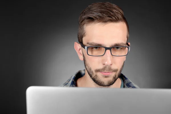 Schöner junger Mann mit Laptop — Stockfoto