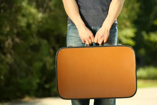 Человек держит винтажный чемодан — стоковое фото