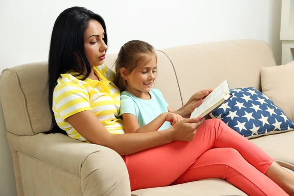 Kleines Mädchen liest Buch mit Mutter — Stockfoto