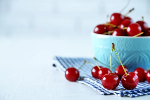 Cherries in mug on table — Stock Photo, Image