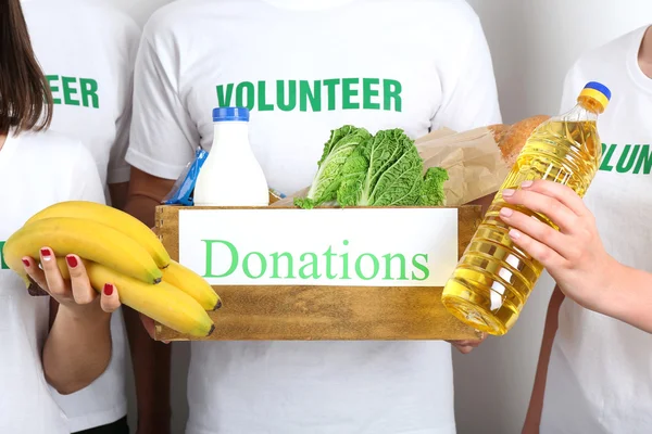 Волонтер в коробке для пожертвований — стоковое фото