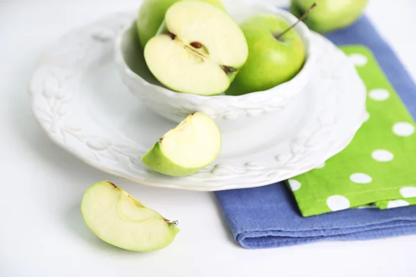 Groene appels in schotel op tafel met servetten, close-up — Stockfoto