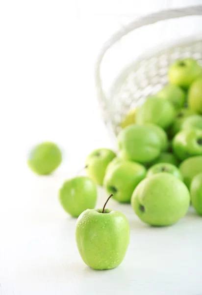 Gröna äpplen i rotting korg, närbild — Stockfoto