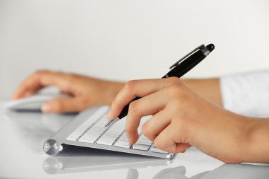 Açık renkli kalem ve bilgisayar fare tutan eller