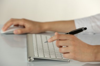 Açık renkli kalem ve bilgisayar fare tutan eller