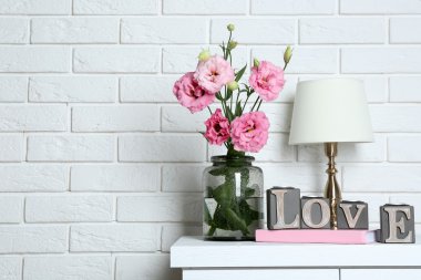 Arka plan güzel çiçekler ile masa lambası üzerinde tuğla duvar