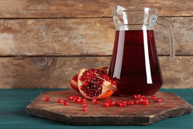 Ahşap zemin üzerine taze meyve suyu nar ve cam sürahi