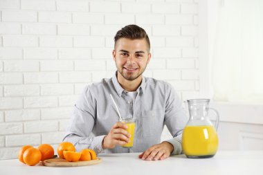 Genç adam bardak portakal suyu gösterilen