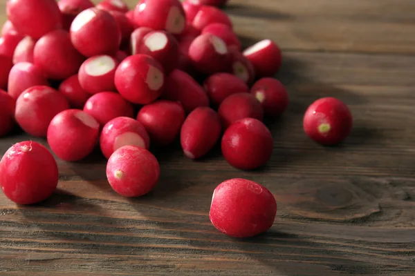 Heap of fresh radishes on wooden table close up background — Stock Photo, Image
