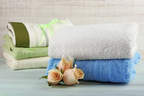 Stoh barevné ručníky na světlé dřevěné pozadí — Stock fotografie