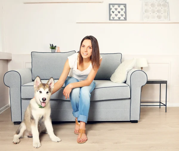 Vrouw en haar hond malamute in kamer — Stockfoto