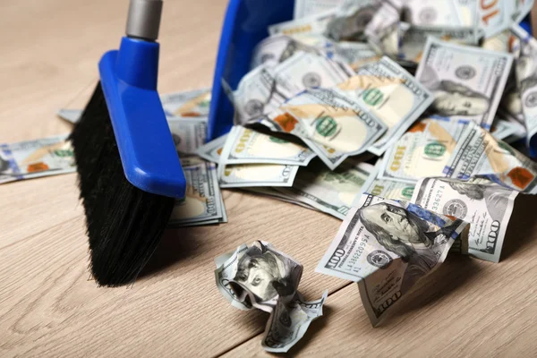 Брум выбрасывает доллары в мусорное ведро — стоковое фото