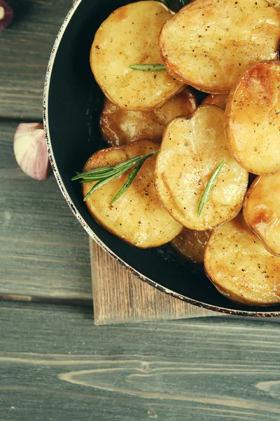 Batata assada deliciosa com alecrim na frigideira na mesa close-up — Fotografia de Stock