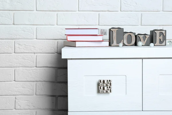 Libros con palabra Amor sobre fondo de pared de ladrillo —  Fotos de Stock