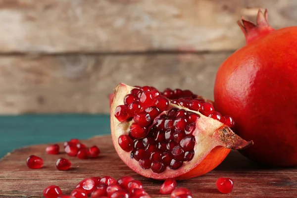 Juicy pomegranate on wooden background — Stock Photo, Image