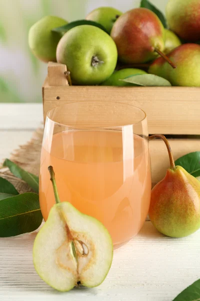 杯与木制的桌子，特写上鲜梨汁 — 图库照片