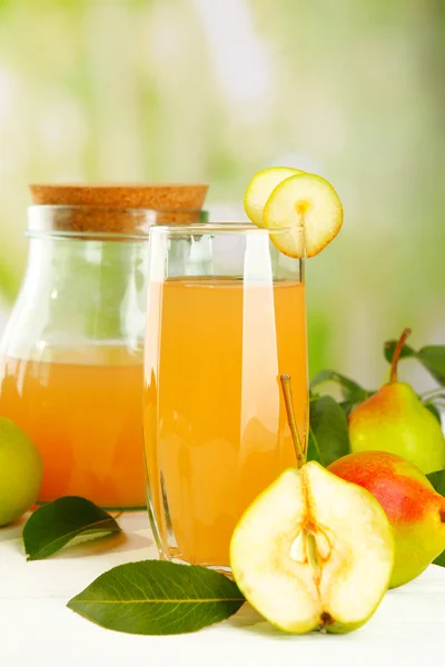 Glass of juice with fresh pears on wooden table on blurred background — Stock Photo, Image